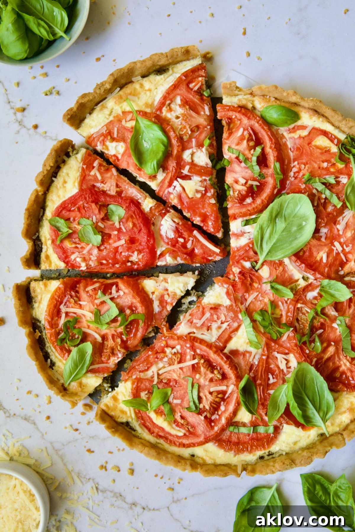 Tomato Tart with Ricotta and Cheese sliced into wedges and garnished with fresh basil leaves.