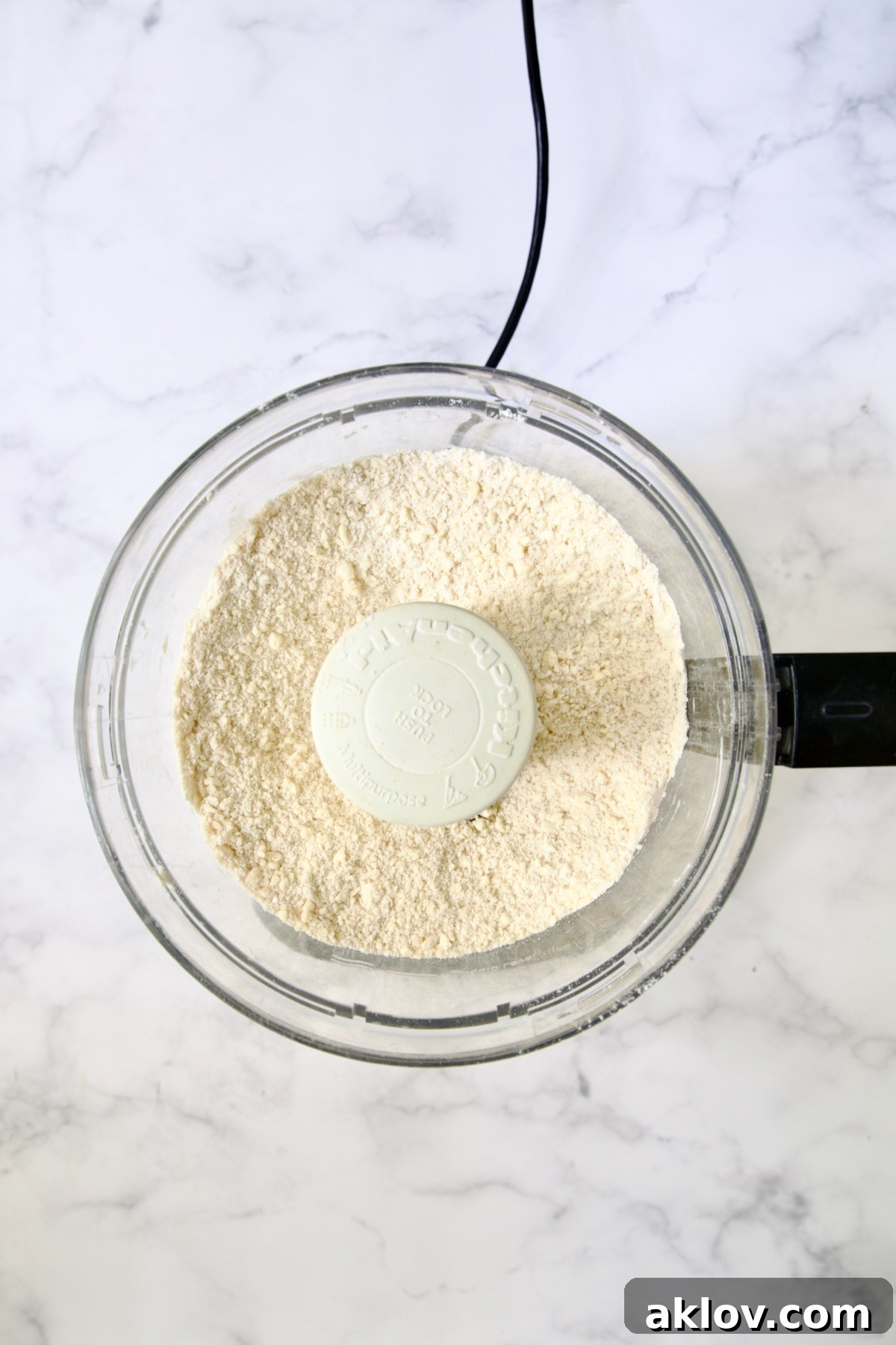 Butter cubes, flour, salt and pepper in bowl of food processor blended together to make a coarse meal.