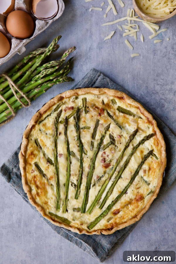 A beautiful Asparagus Tart with Prosciutto and Fontina cheese, showcasing its golden crust and vibrant green asparagus.