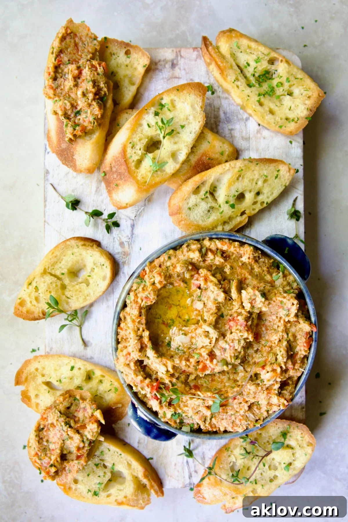 Artichoke Tapenade on crostini, elegantly arranged on a whitewashed board with fresh thyme garnish.
