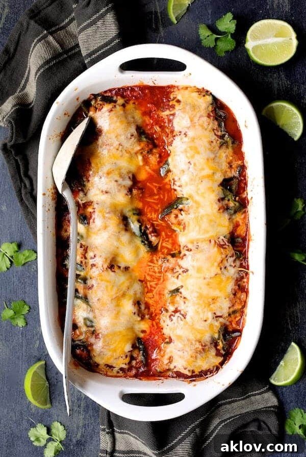 Stuffed peppers in white baking dish garnished with limes and cilantro sprigs after being baked.