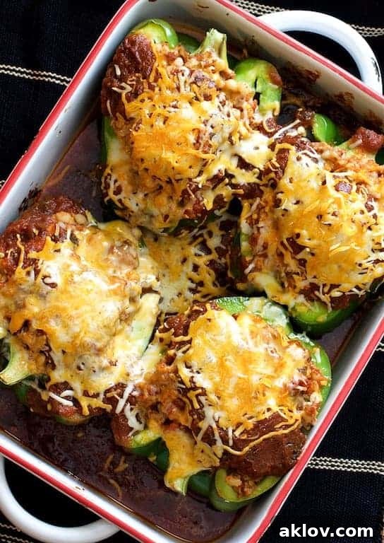 Four Southwestern Beef and Barley Stuffed Bell Peppers in white baking dish.