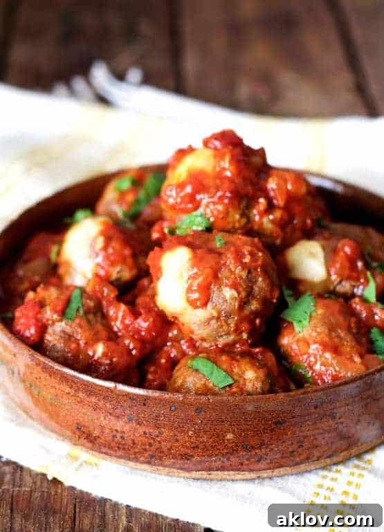 Pepperjack-Stuffed Meatballs with Chipotle Sauce in earthenware serving bowl.