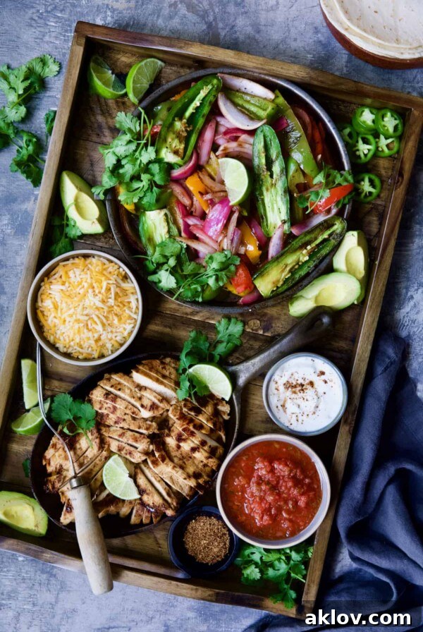 Grilled Tajin-Seasoned Chicken Fajitas on wood board with all the accompaniments.