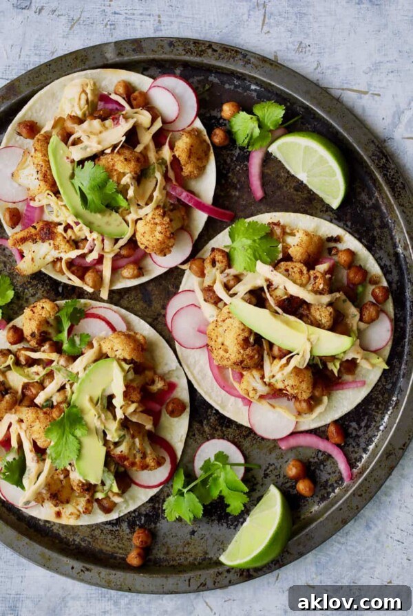 Overhead close-up shot of three tacos on round platter