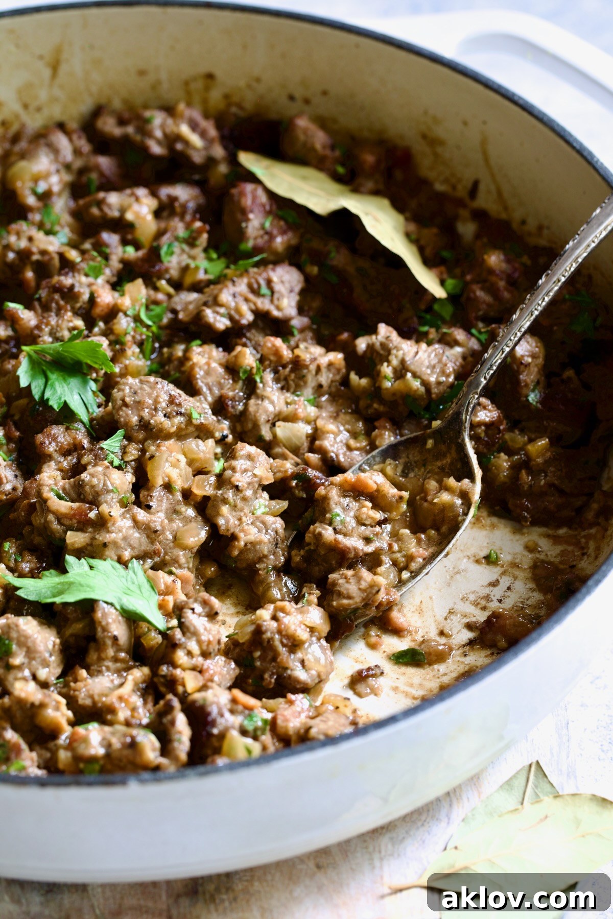 A close-up shot of the Beer-Infused Beef Tips (Picadinho na Cerveja) bubbling in a white enamel cast iron skillet, ready to be served.