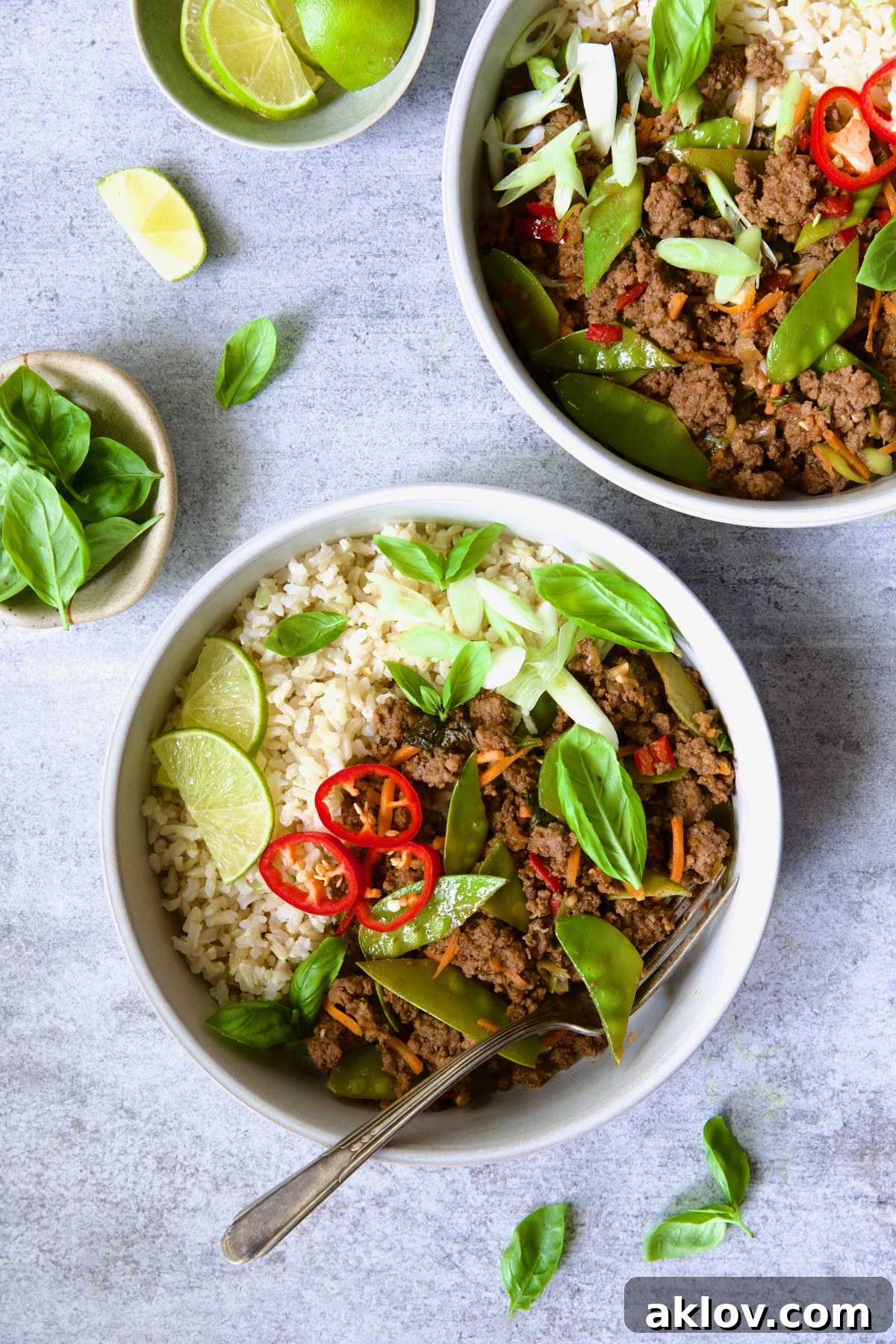 Two enticing bowls of Thai Basil Beef, perfectly portioned and garnished, ready to be enjoyed, showcasing the vibrant colors and inviting presentation of the dish.
