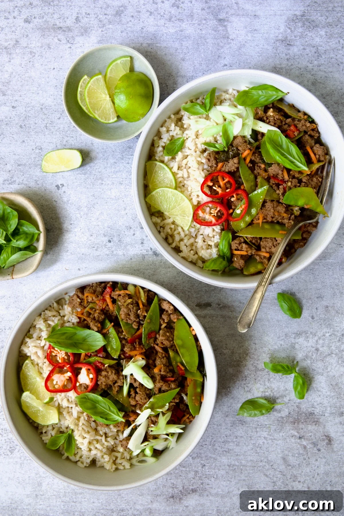 Spicy Thai Basil Beef Stir-fry 16 A generous serving of Thai Basil Beef in two white bowls, showcasing the rich sauce, tender beef, and crisp vegetables.