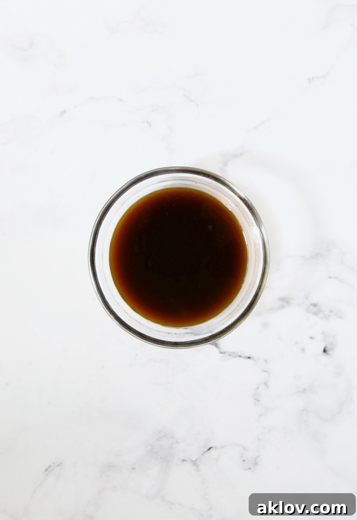 A glass bowl filled with the homemade Thai Basil Beef stir-fry sauce, a harmonious blend of soy sauce, lime, Sriracha, and other seasonings, ready to be incorporated into the dish.