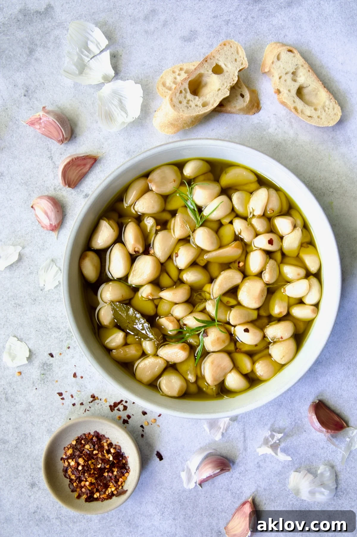 A rustic earthenware bowl filled with luscious garlic confit, glistening with olive oil and ready for serving.