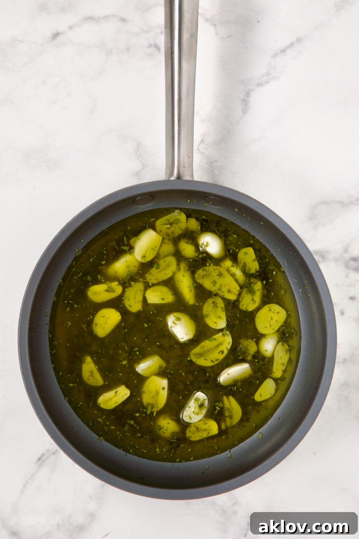 Sliced garlic and herbs in nonstick skillet.