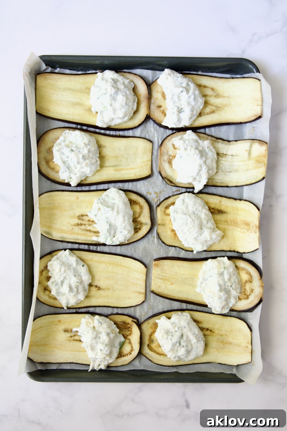 Filling placed on baked eggplant slices before being rolled up.