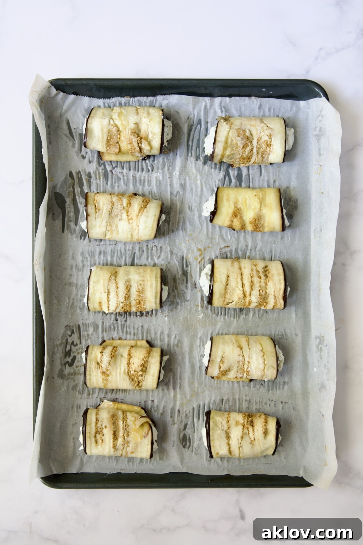Then cheese-filled eggplant rolls on parchment paper-lined baking sheet.