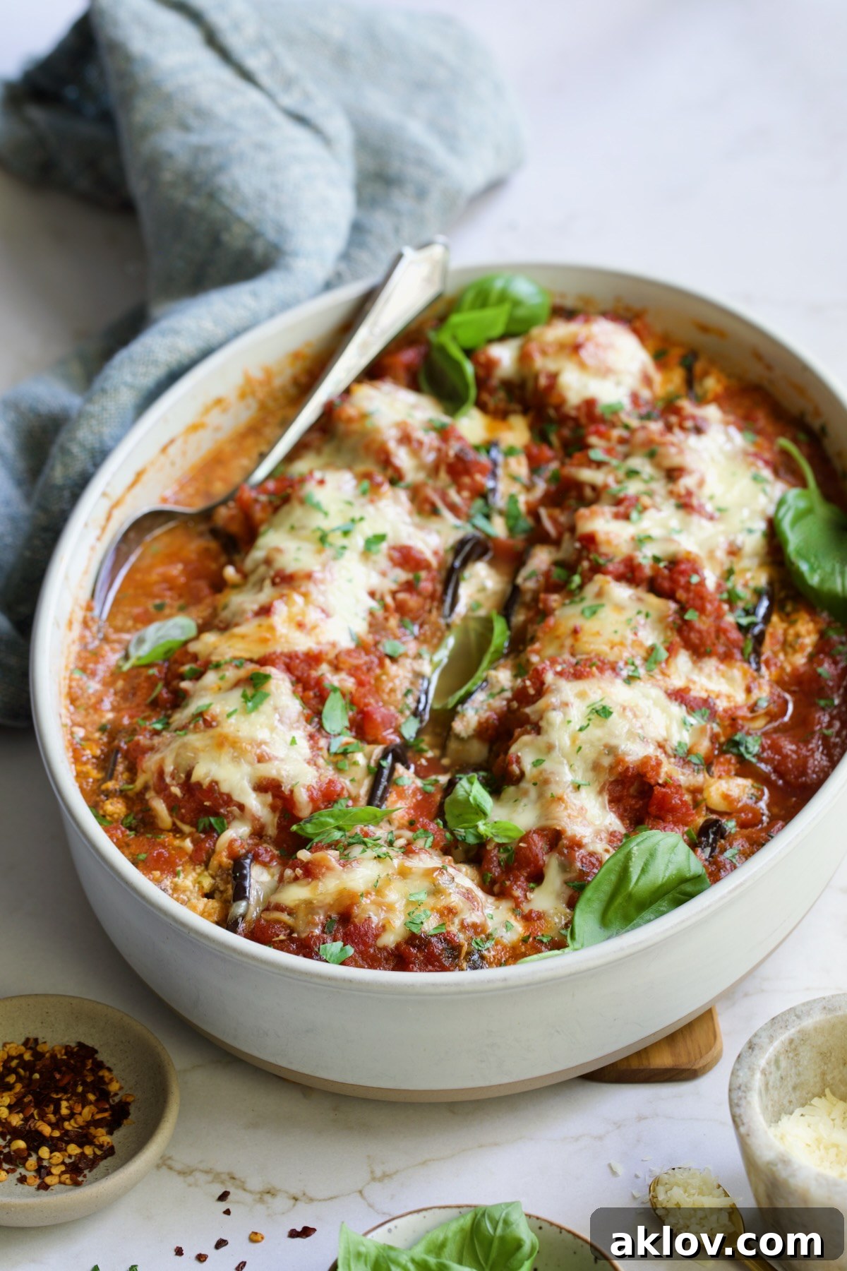 Baked Four-Cheese Eggplant Rollatini with serving spoon.