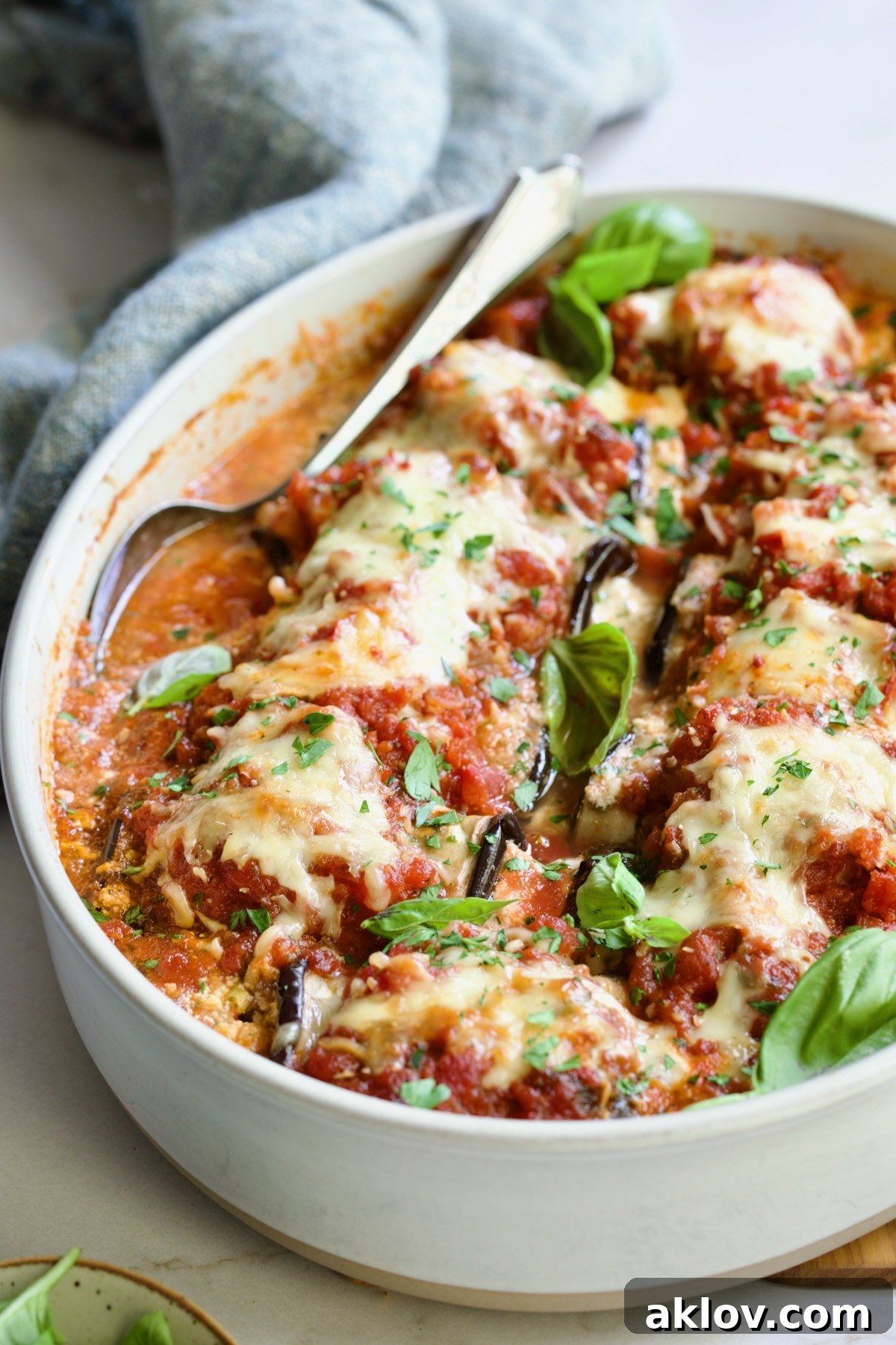 Baked Four-Cheese Eggplant Rollatini with serving spoon.