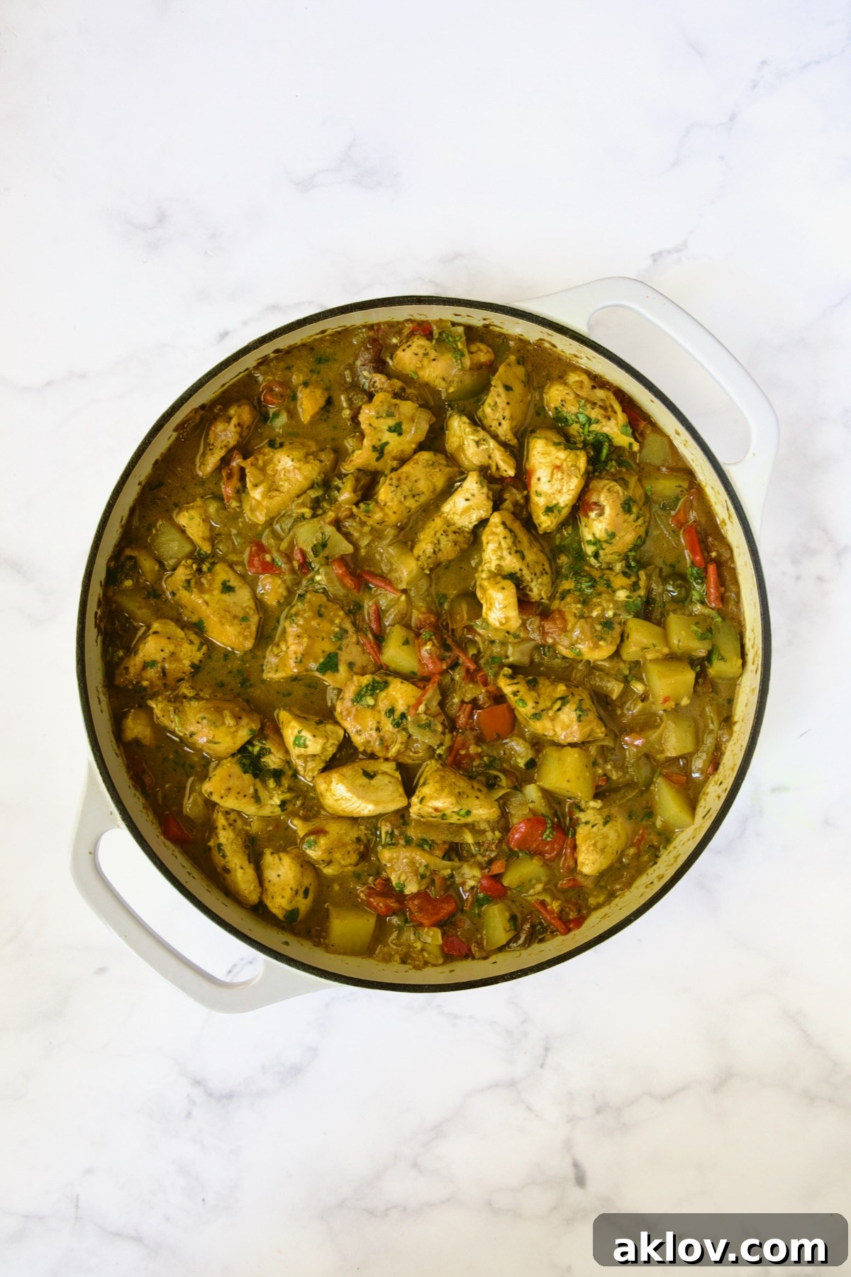 Finished Chicken and Potato Curry in white enamel cast iron skillet.