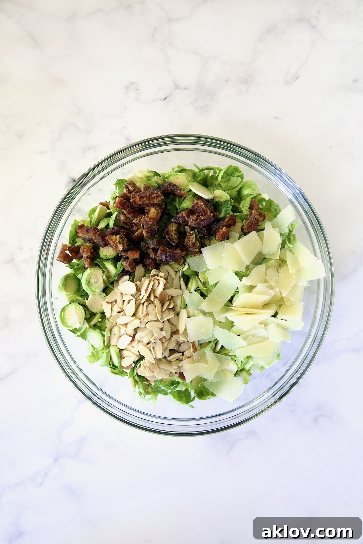 Zingy Shaved Brussels Salad 8 Shaved Brussels sprouts, finely chopped dates, perfectly sliced almonds, and delicate shavings of Romano cheese artfully arranged in a glass bowl, awaiting their delicious combination.
