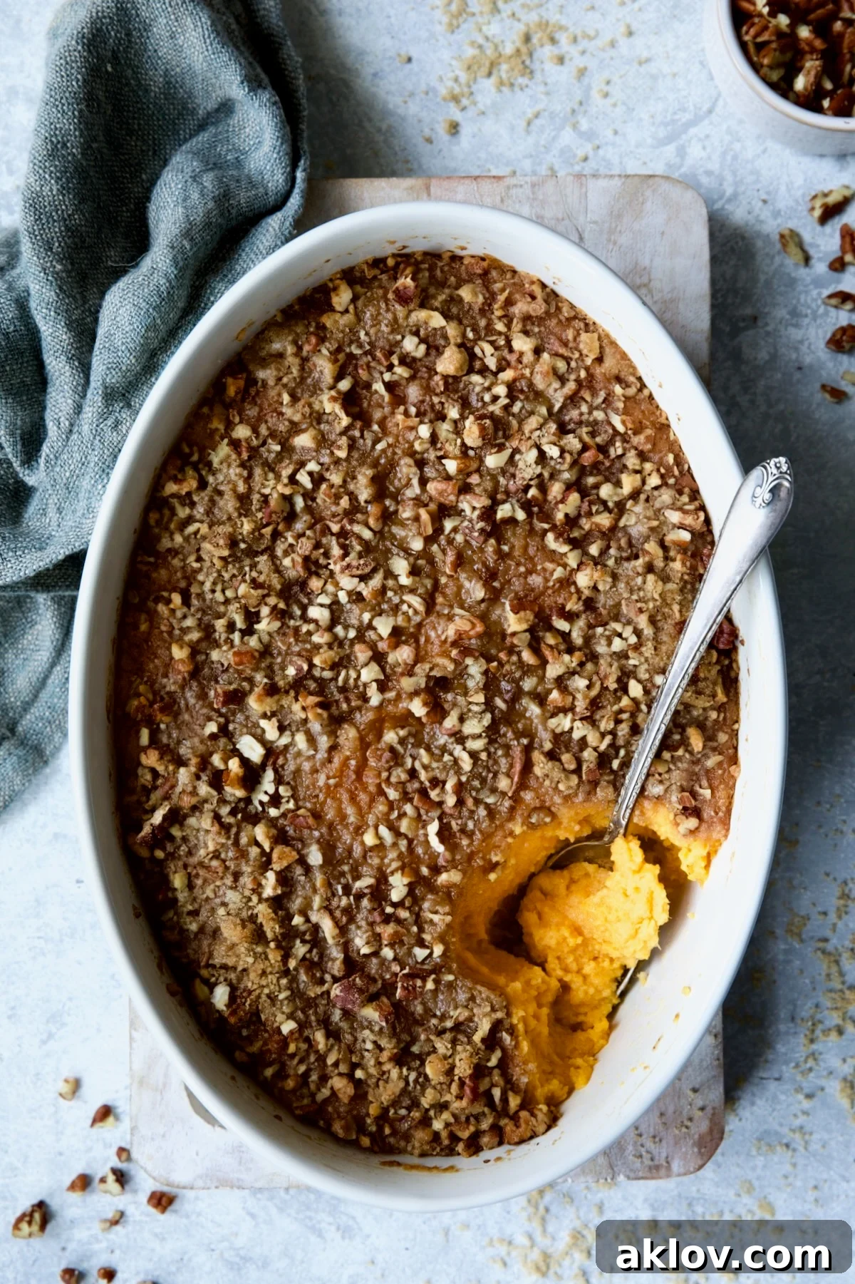Sweet Potato Souffle in oval baking dish with serving spoon. A luxurious and inviting holiday side dish.