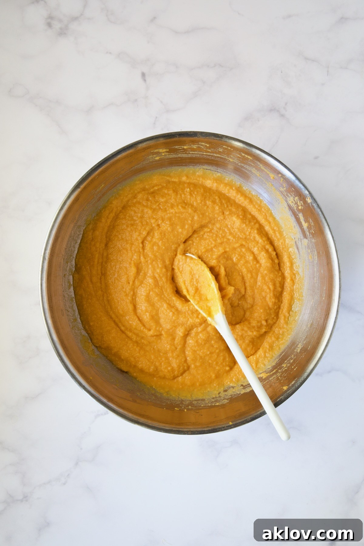 The fully combined sweet potato mixture in a stainless steel mixing bowl, ready for baking.