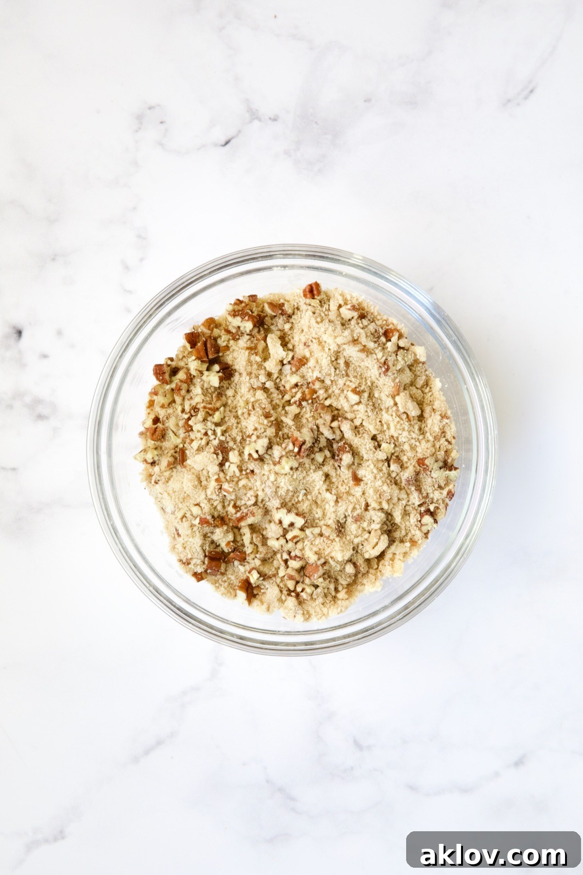 Pecan streusel topping, a delicious mix of nuts, brown sugar, flour, and butter, prepared in a glass bowl.
