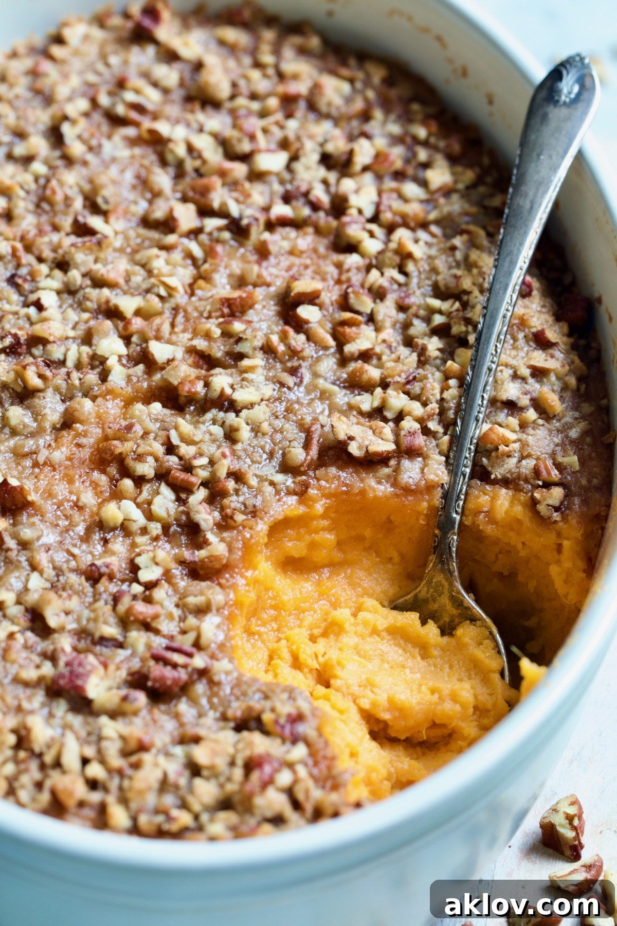 A close-up of the Sweet Potato Souffle in an oval baking dish, showcasing its perfect texture and golden pecan topping.