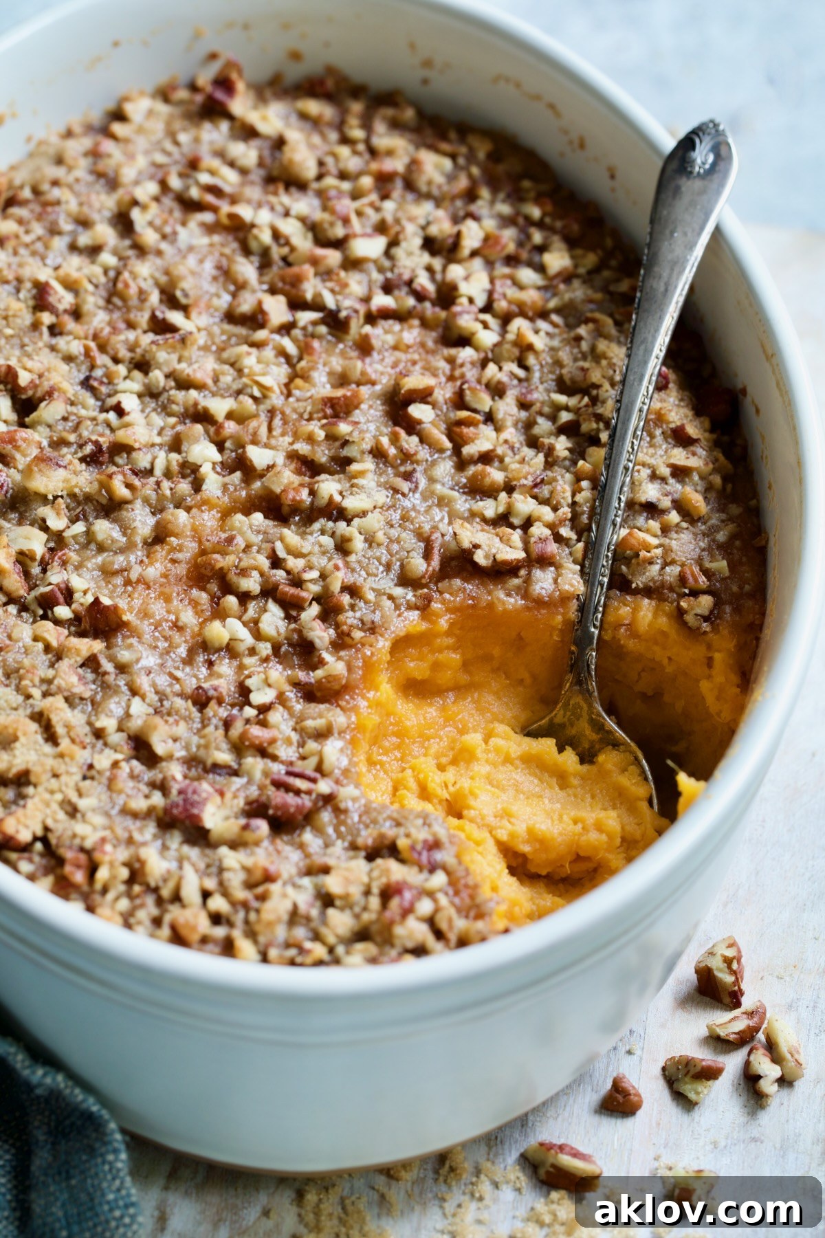 Sweet Potato Souffle in oval baking dish with serving spoon, ready to be enjoyed.