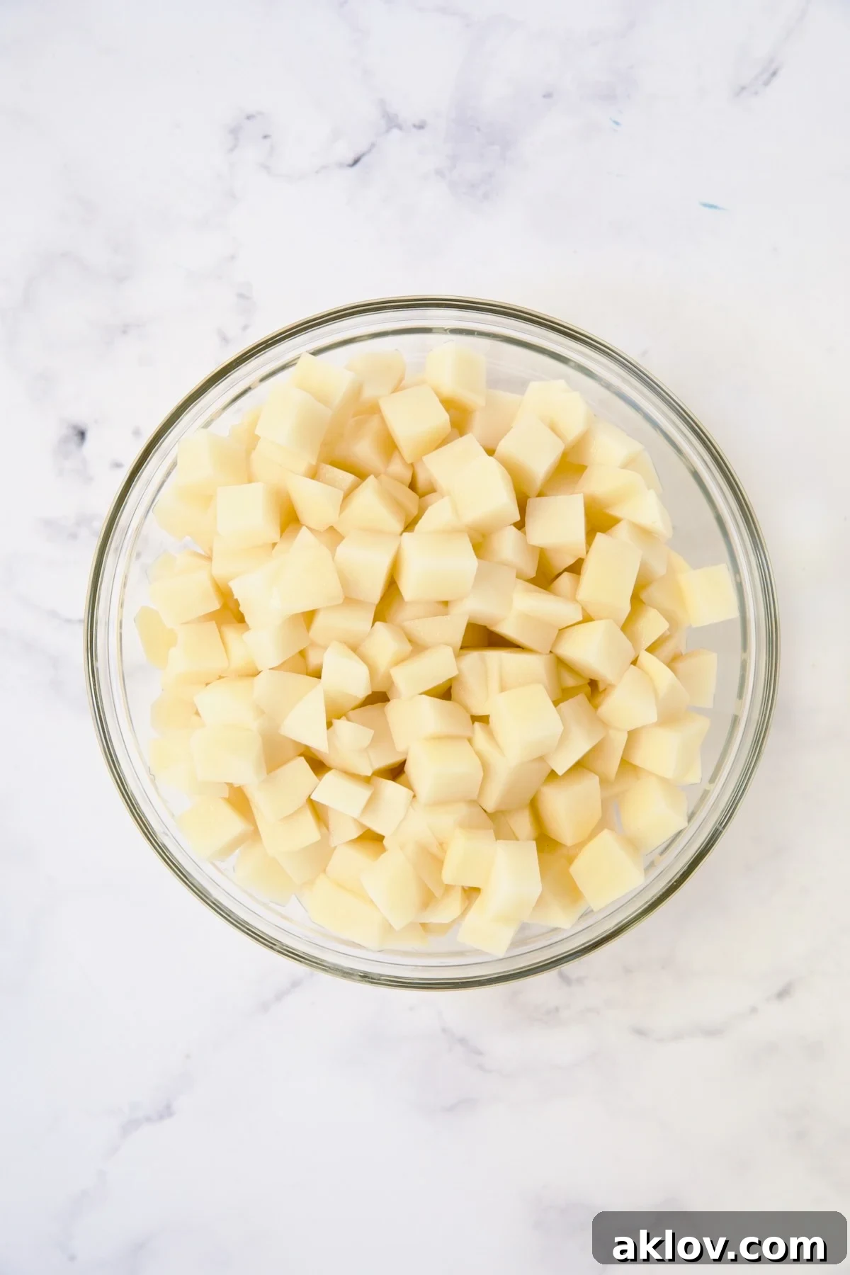 Cubed potatoes in glass bowl.