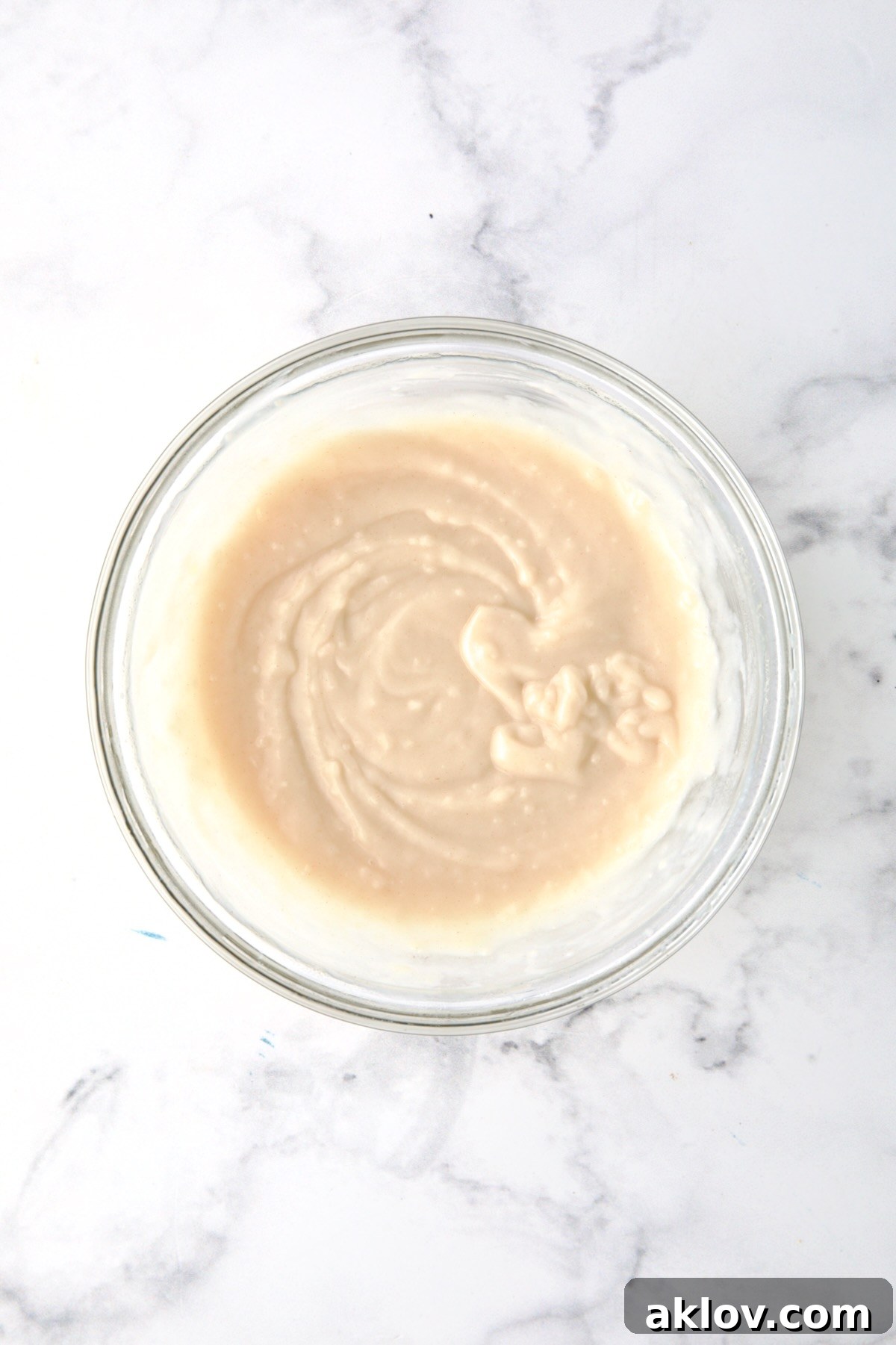 A smooth, lump-free slurry created from flour and cooking broth in a glass bowl.