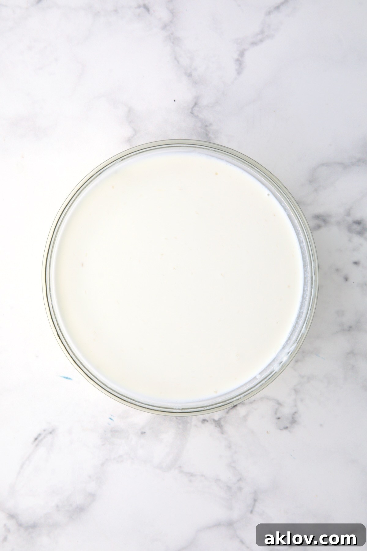 The flour slurry perfectly combined with half-and-half in a glass bowl.