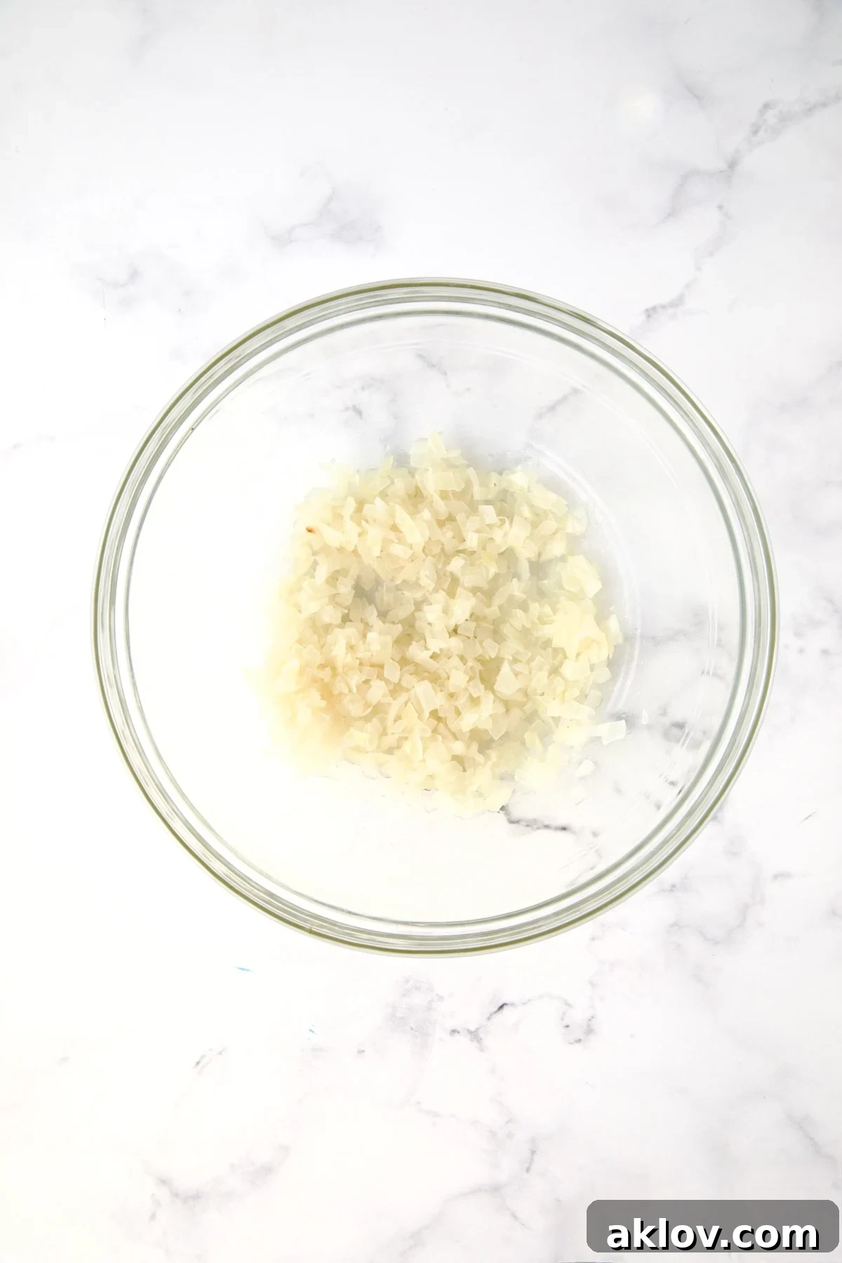 Half of the cooked onions in glass bowl.