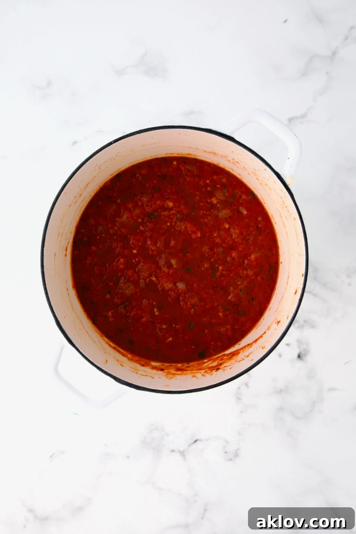 Tomato sauce in white Dutch oven.