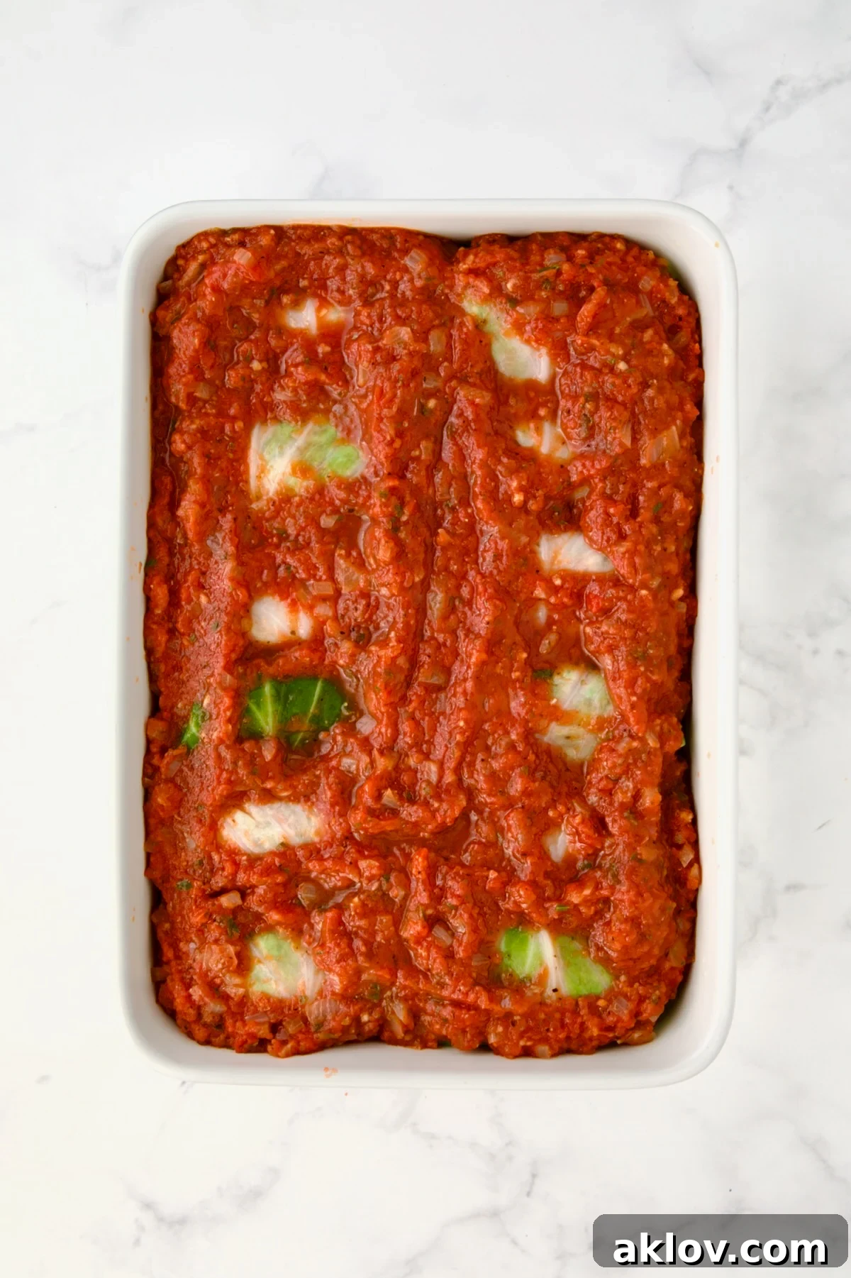 Sauced cabbage rolls ready to be baked.