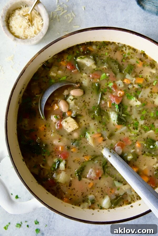 Finished soup in white Dutch oven with soup ladle.