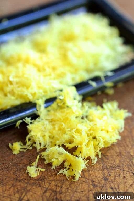 Photo of lemon zest on wooden surface with grater.