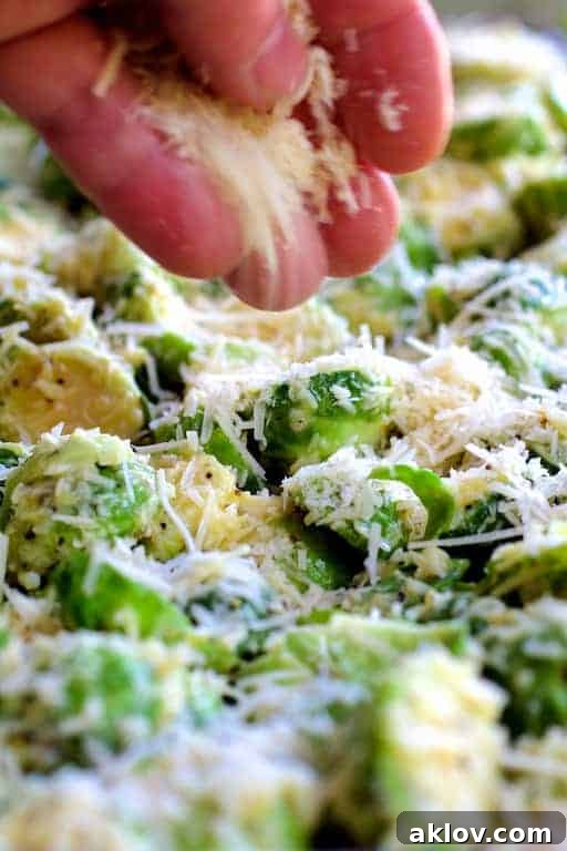 Photo of Brussels sprouts being sprinkled with Parmesan cheese.