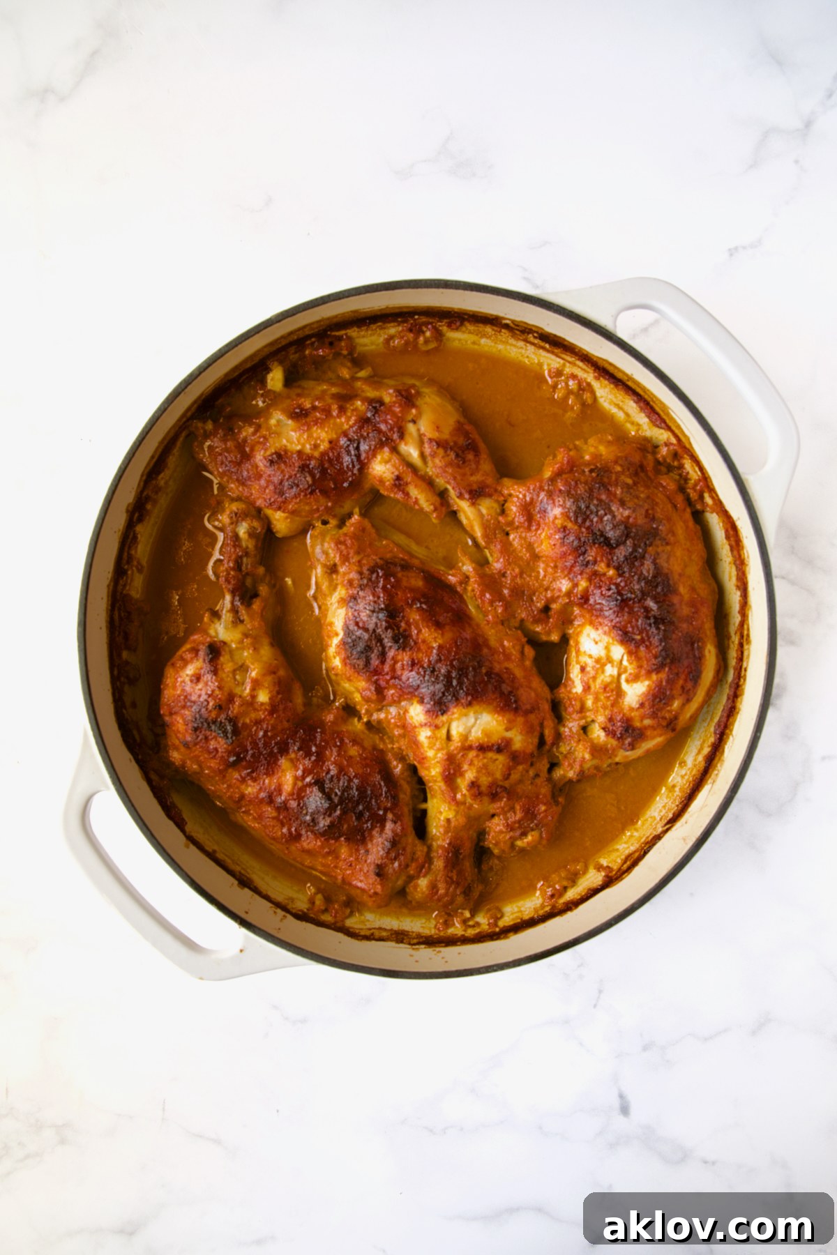 Spicy Thai Red Curry Chicken Drumsticks 7 Braised chicken legs in white enamel cast iron skillet without any garnishes.