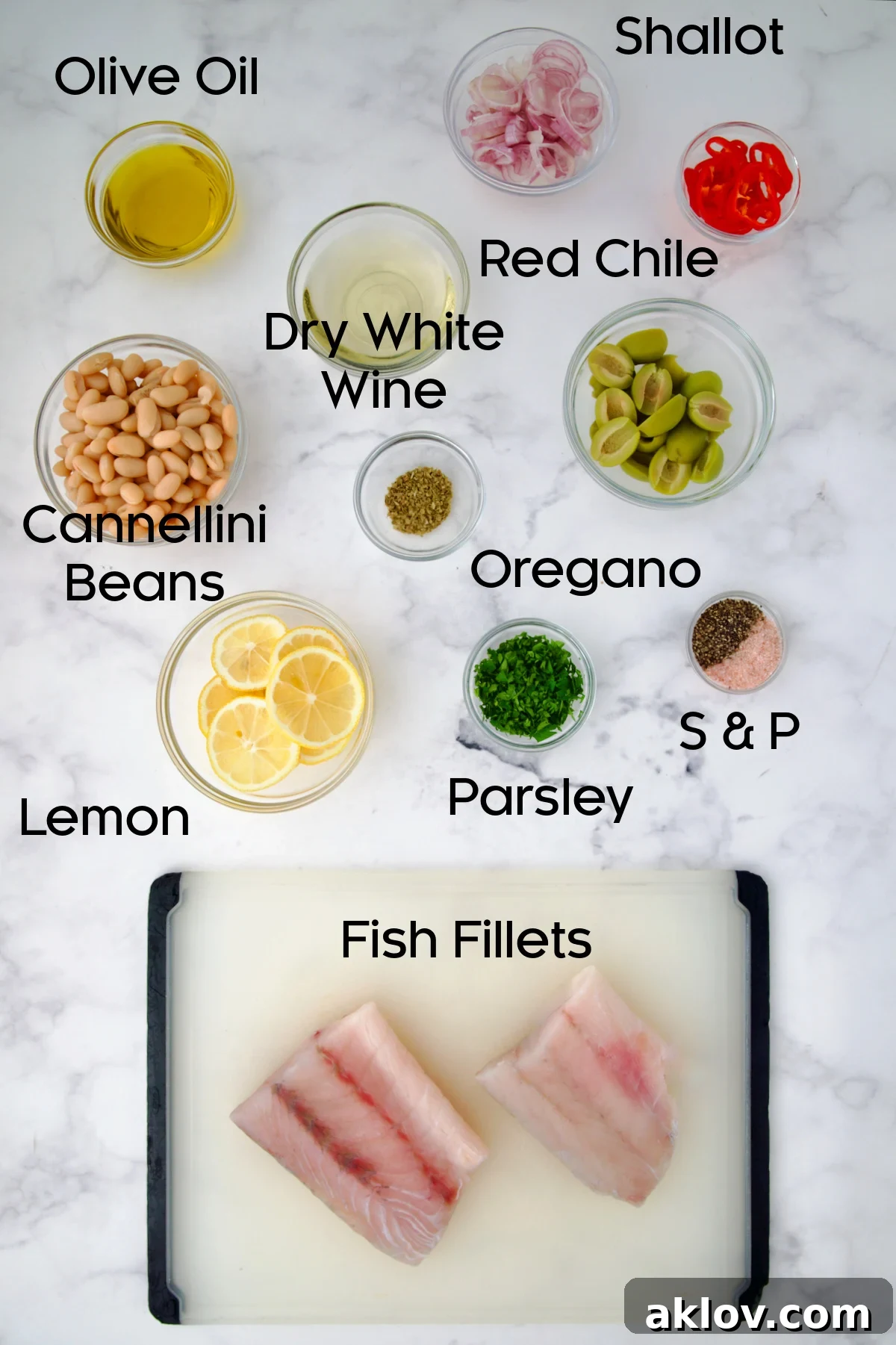 Ingredients for Mediterranean Fish and White Bean Skillet on marble countertop.