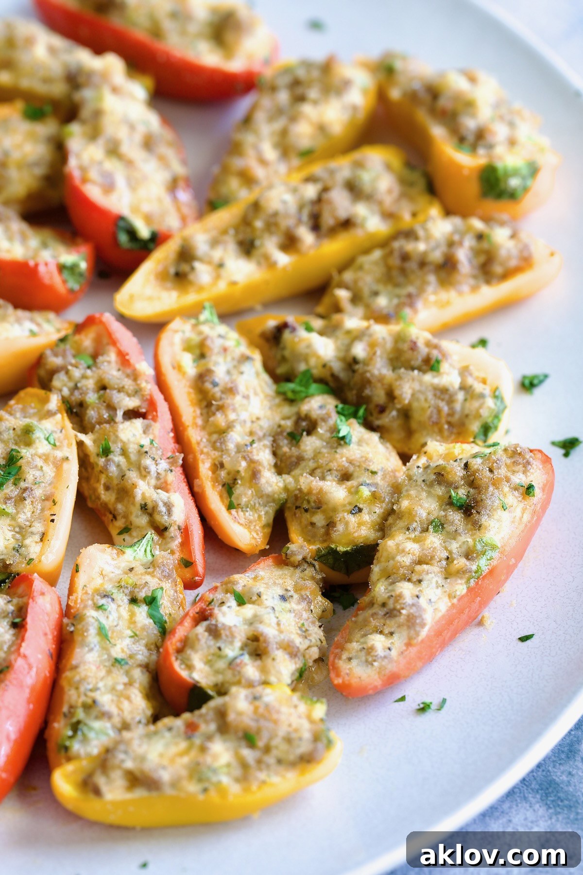 A vibrant platter of baked Stuffed Mini Peppers garnished with fresh parsley, ready to be served.