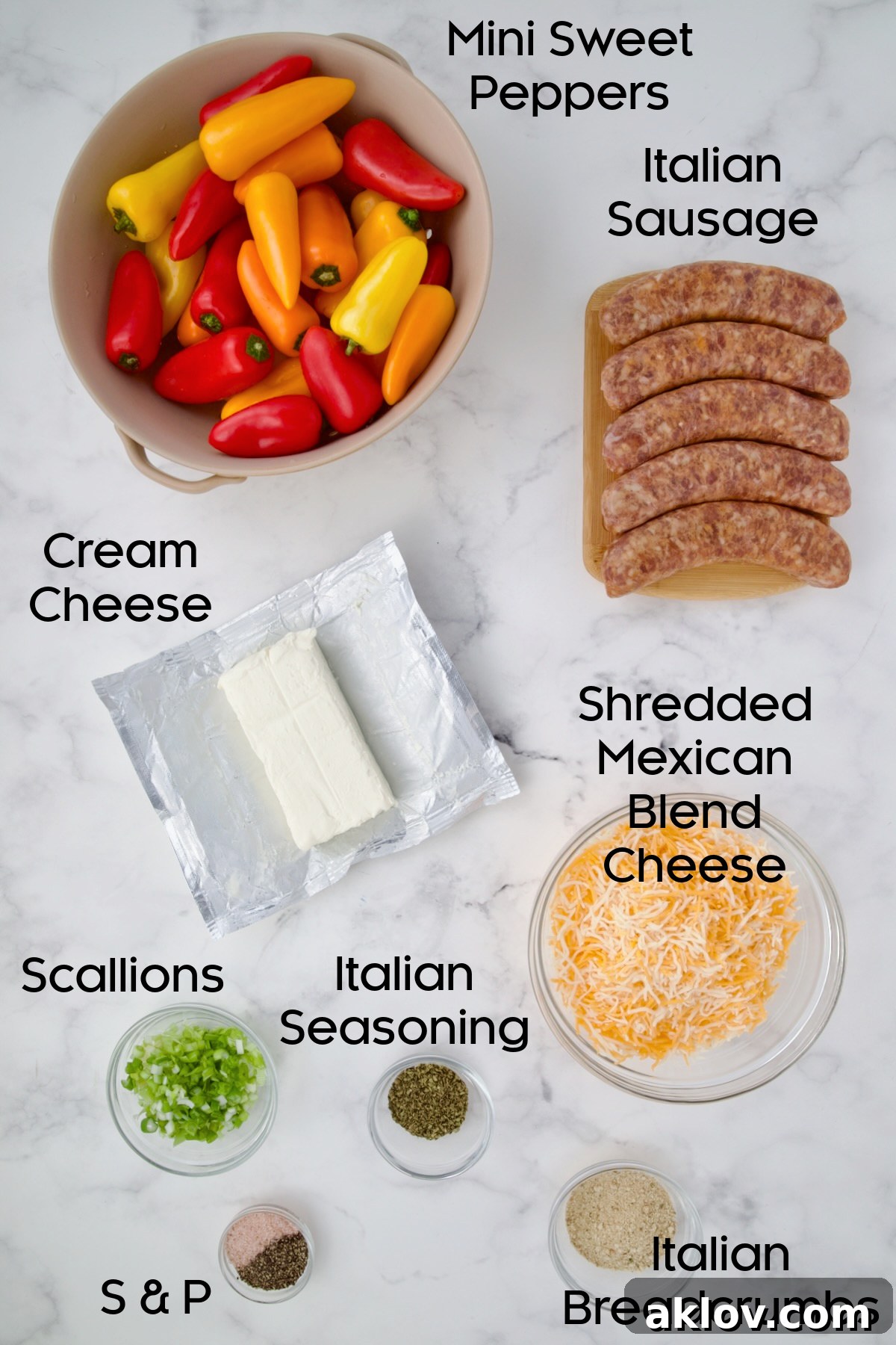 Arrangement of fresh ingredients for Stuffed Mini Peppers on a white marble countertop, including peppers, sausage, cheese, and seasonings.
