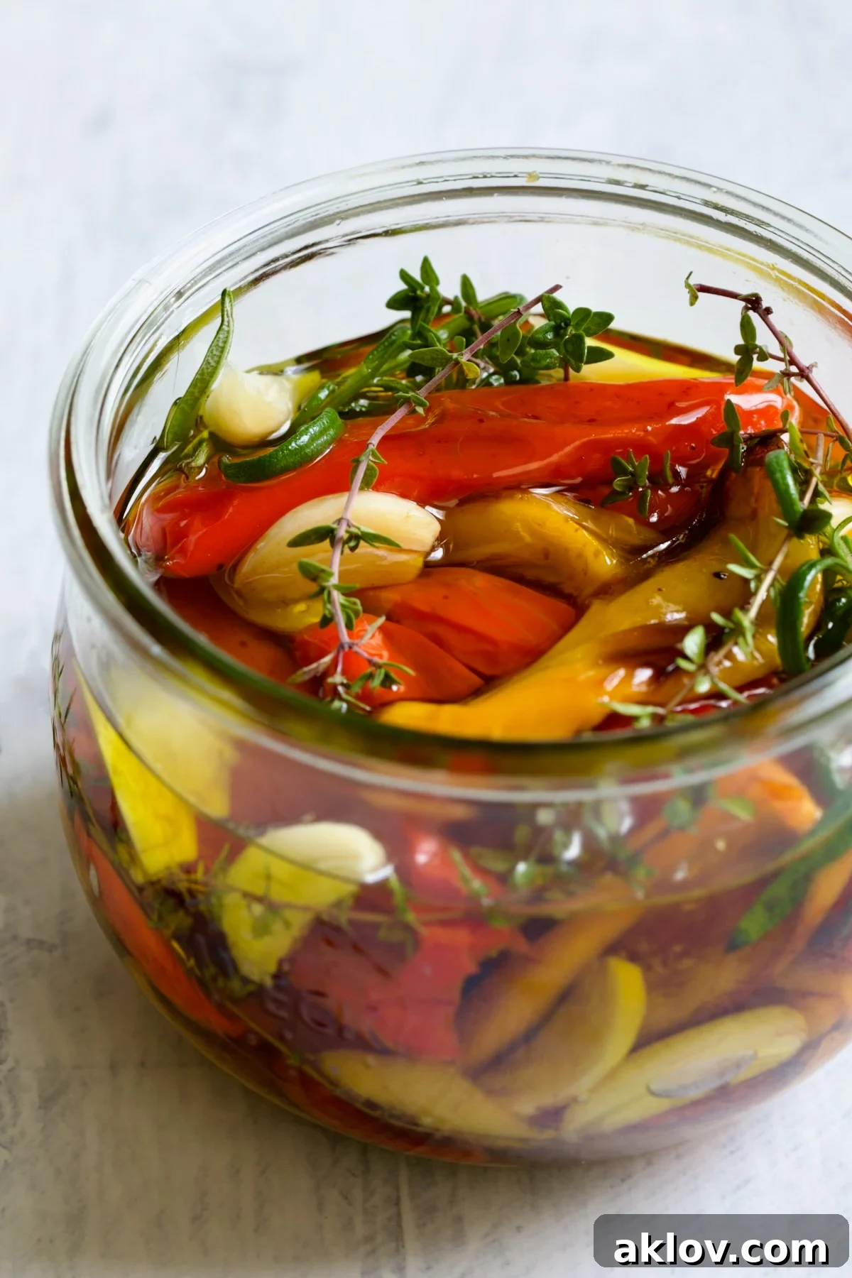 Caramelized Mini Peppers 2 Roasted Mini Peppers in glass jar with fresh herbs and garlic.
