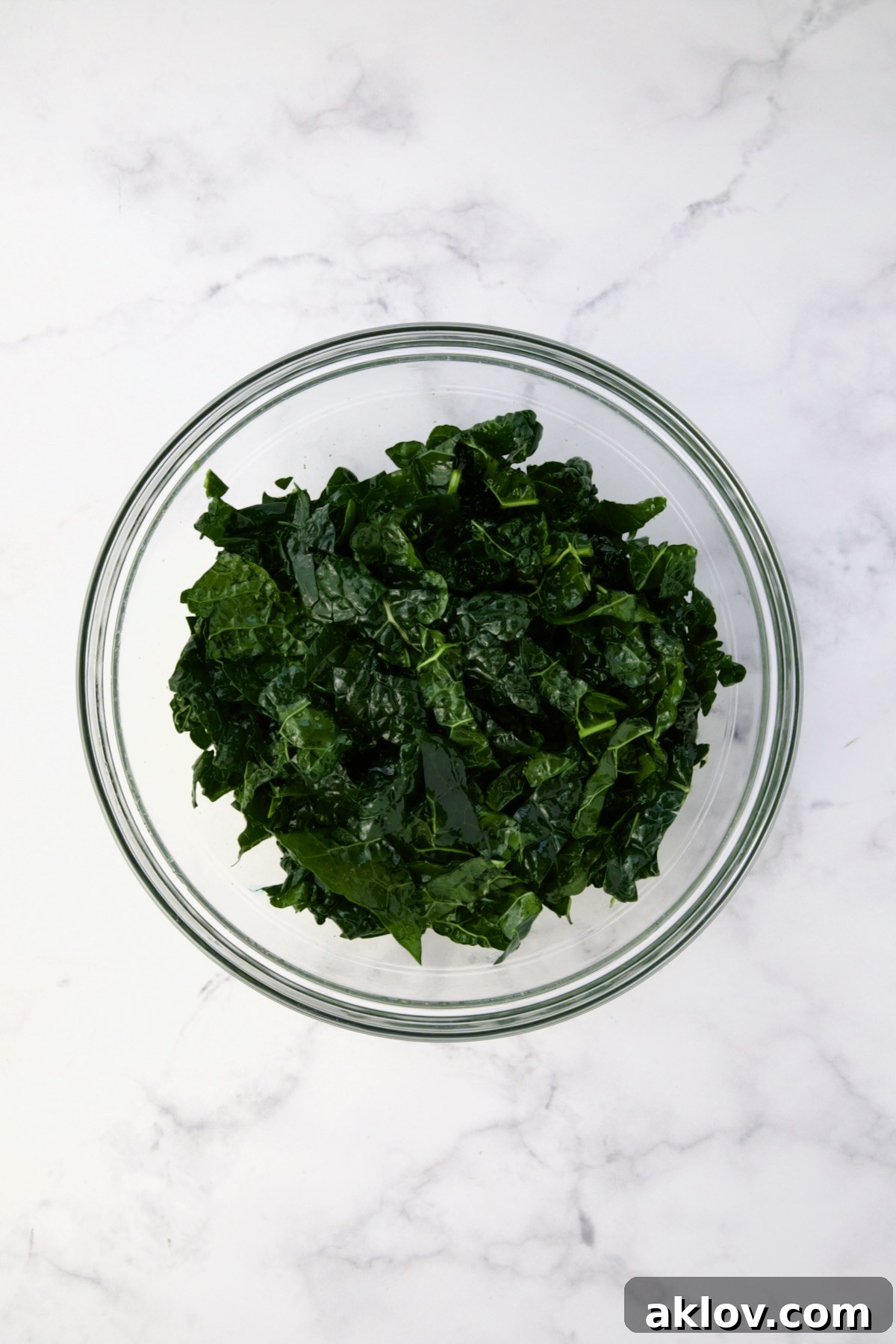 Tuscan kale in glass bowl after being massaged.