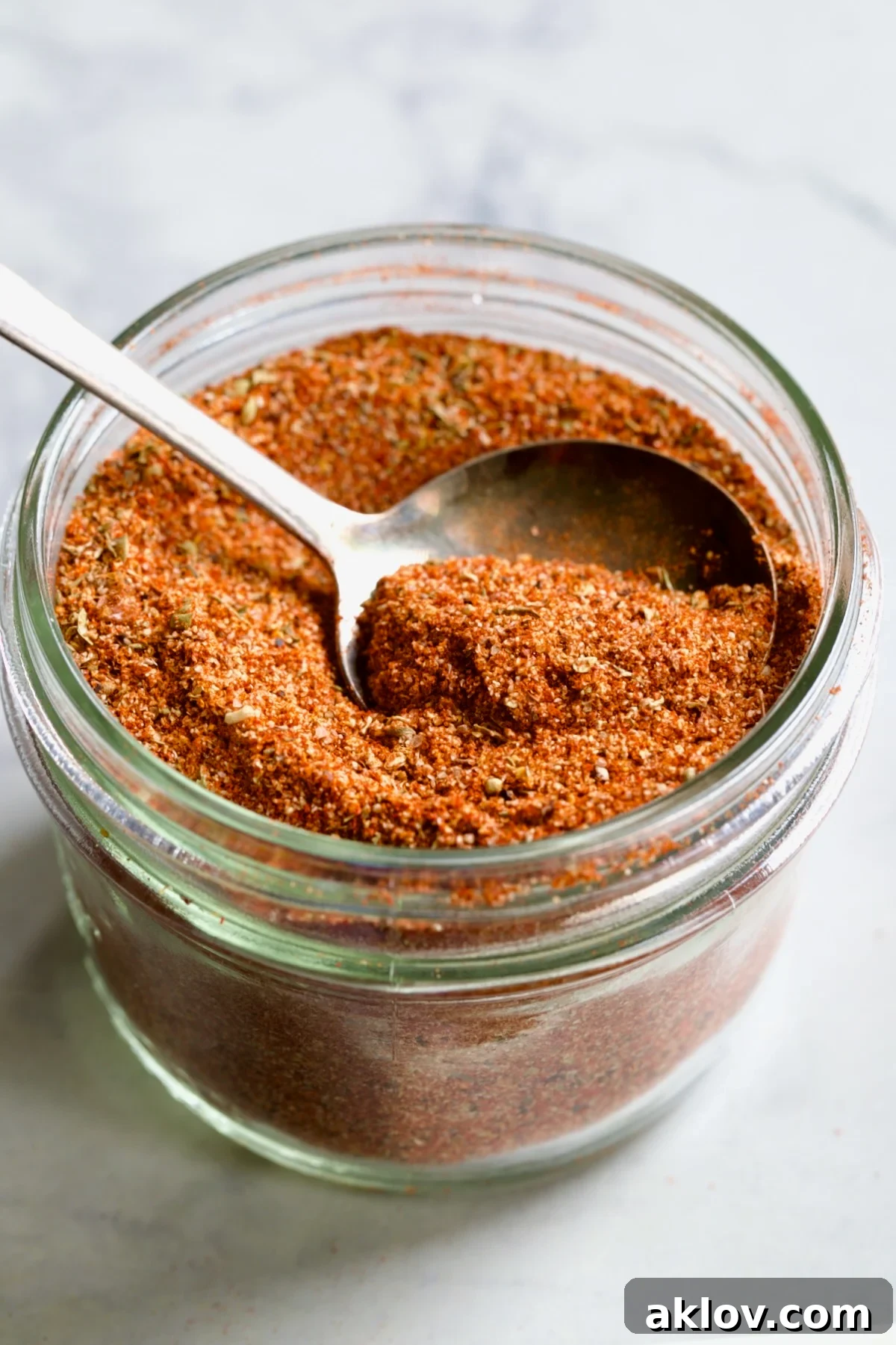 Jar of Blackening Seasoning with spoon scooping some out.