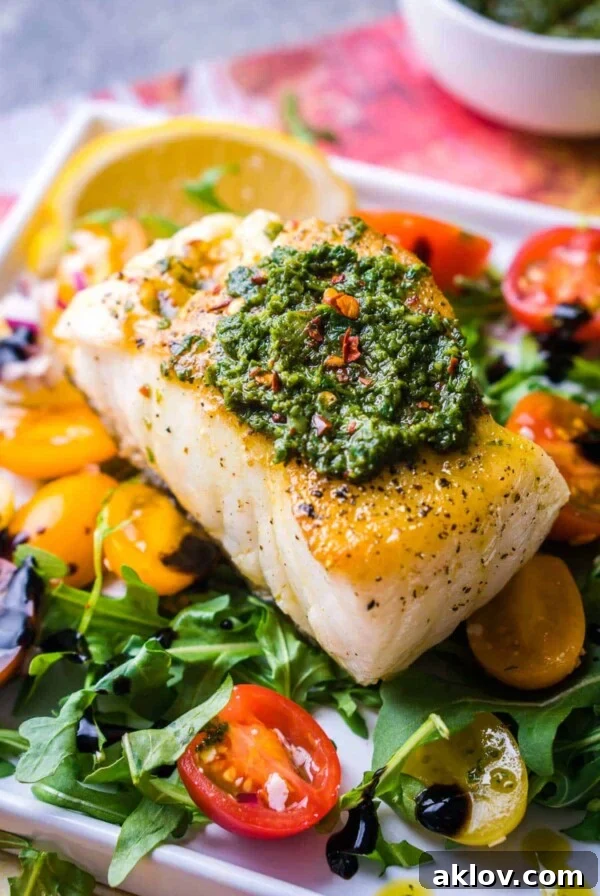 Pan-Seared Chilean Sea Bass with Arugula Pesto, garnished with fresh herbs, showcasing a gourmet meal.