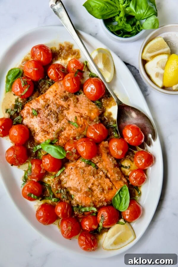 Salmon with Balsamic Cherry Tomatoes served on an oval white platter with a serving fork, highlighting a bright and savory meal.