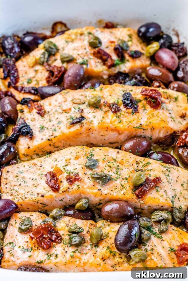Mediterranean Baked Salmon fillets topped with garlic, kalamata olives, sun-dried tomatoes, capers, and fresh dill, roasted to tender perfection.