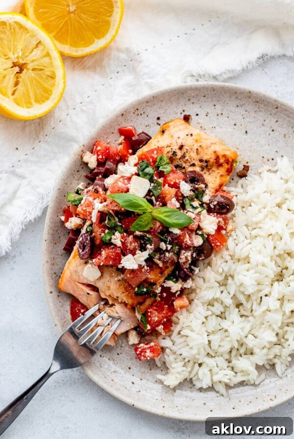 Pan-fried Salmon with Mediterranean Salsa served on a plate with a side of rice, presenting a flavorful and healthy meal.