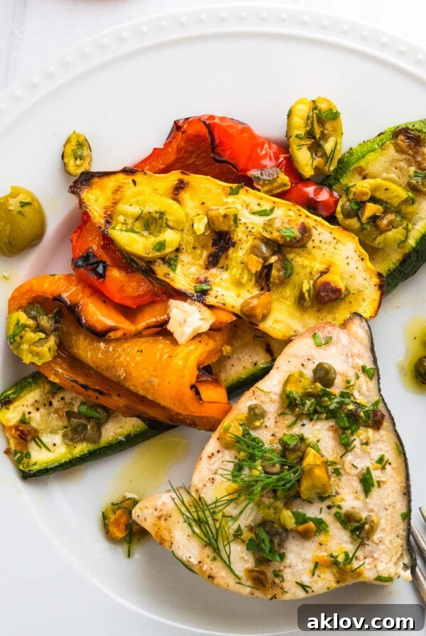 Grilled Swordfish Steaks on a white plate with a vibrant olive relish, perfect for a healthy dinner.