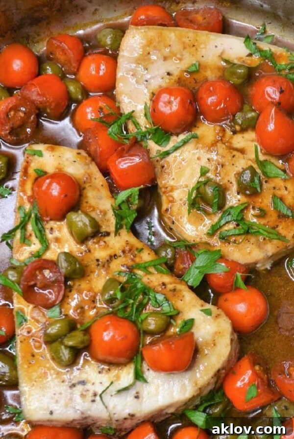 Pan-Roasted Swordfish with Burst Cherry Tomatoes and Capers, a delicious fish dinner ready in under 30 minutes.