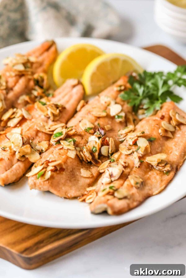 Trout Almondine served on a white plate with fresh lemon wedges, showcasing a fast, easy, and delicious meal.