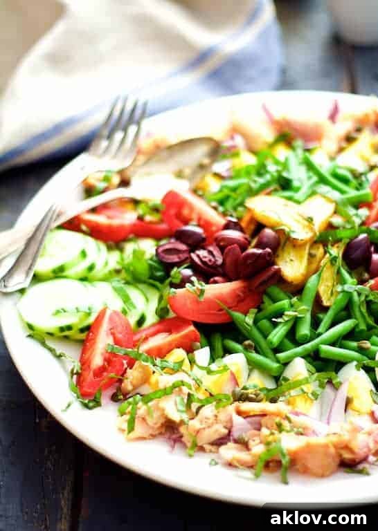 Salade Nicoise on a white platter, a show-stopping salad perfect for a spring or summer dinner, featuring tuna or trout.